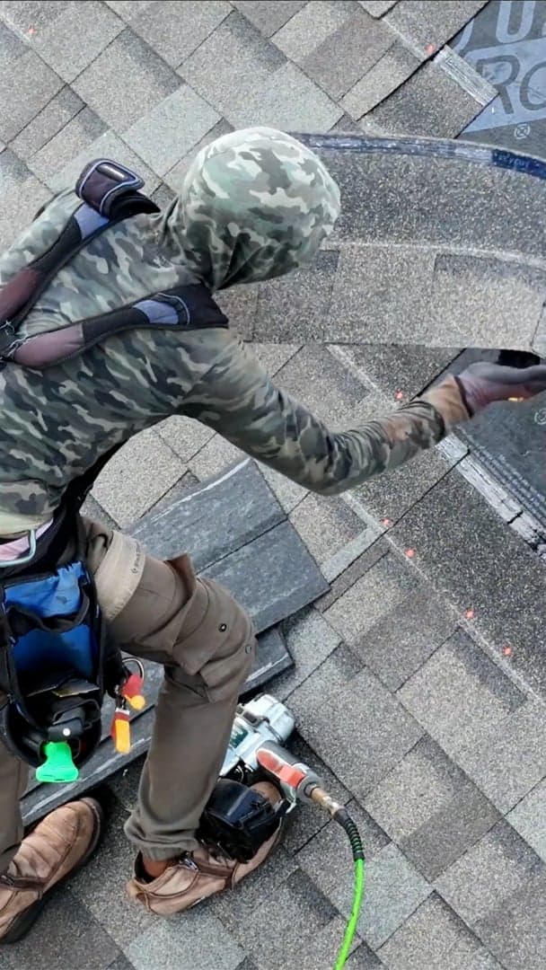 A roofer working across underlayment dotted with clearly visible orange LumaNail fasteners.